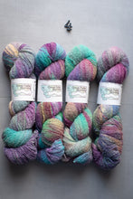 Load image into Gallery viewer, Multicolored yarn skeins with labels on a gray background