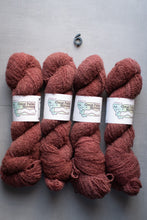 Load image into Gallery viewer, Four skeins of maroon yarn with labels on a gray background