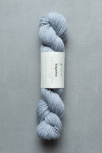 Load image into Gallery viewer, Blue skein of yarn with a label on a gray background