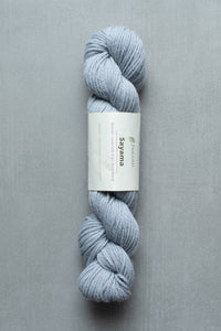 Blue skein of yarn with a label on a gray background