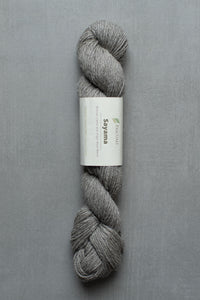 Gray skein of yarn with a label on a gray background