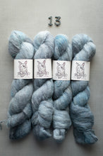Load image into Gallery viewer, Four skeins of blue yarn with labels on a gray background