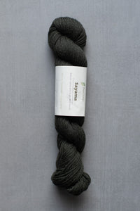 Dark gray skein of yarn with a label on a gray background