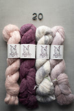 Load image into Gallery viewer, Four skeins of yarn in pink, purple, and gray on a gray background with 'Old Dog Yarn' labels.