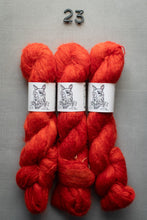 Load image into Gallery viewer, Three skeins of red yarn with labels on a gray background