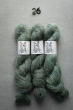 Load image into Gallery viewer, Three skeins of green yarn with labels on a gray background