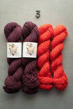 Load image into Gallery viewer, Two skeins of dark purple yarn and two skeins of red yarn on a gray background with 'sakari' labels.