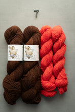 Load image into Gallery viewer, Two skeins of brown yarn and two skeins of red yarn on a gray background with a number 7.
