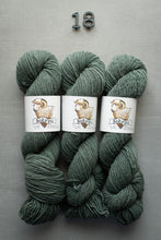 Load image into Gallery viewer, Three skeins of green yarn with labels on a gray background