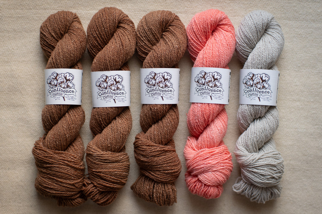 Five skeins of yarn in brown, pink, and gray on a neutral background with labels.