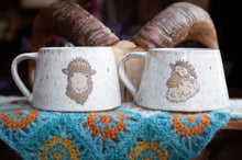 Load image into Gallery viewer, Two ceramic mugs with animal illustrations on a textured surface