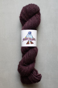 Purple skein of yarn with a label on a gray background