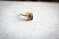 Gold ring with a smoky topaz stone on a textured surface