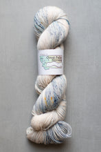 Load image into Gallery viewer, Yarn skein with a label on a gray background