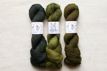 Load image into Gallery viewer, Three skeins of green yarn on a white background with labels.