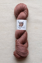 Load image into Gallery viewer, Ball of pink yarn with a label on a beige background
