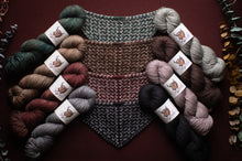 Load image into Gallery viewer, Knitted swatch with skeins of yarn on a dark background