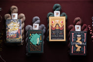 Four books on a dark background with yarn balls