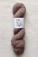 Load image into Gallery viewer, Brown skein of yarn with a label on a beige background