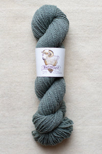 Blue skein of yarn with a label on a beige background