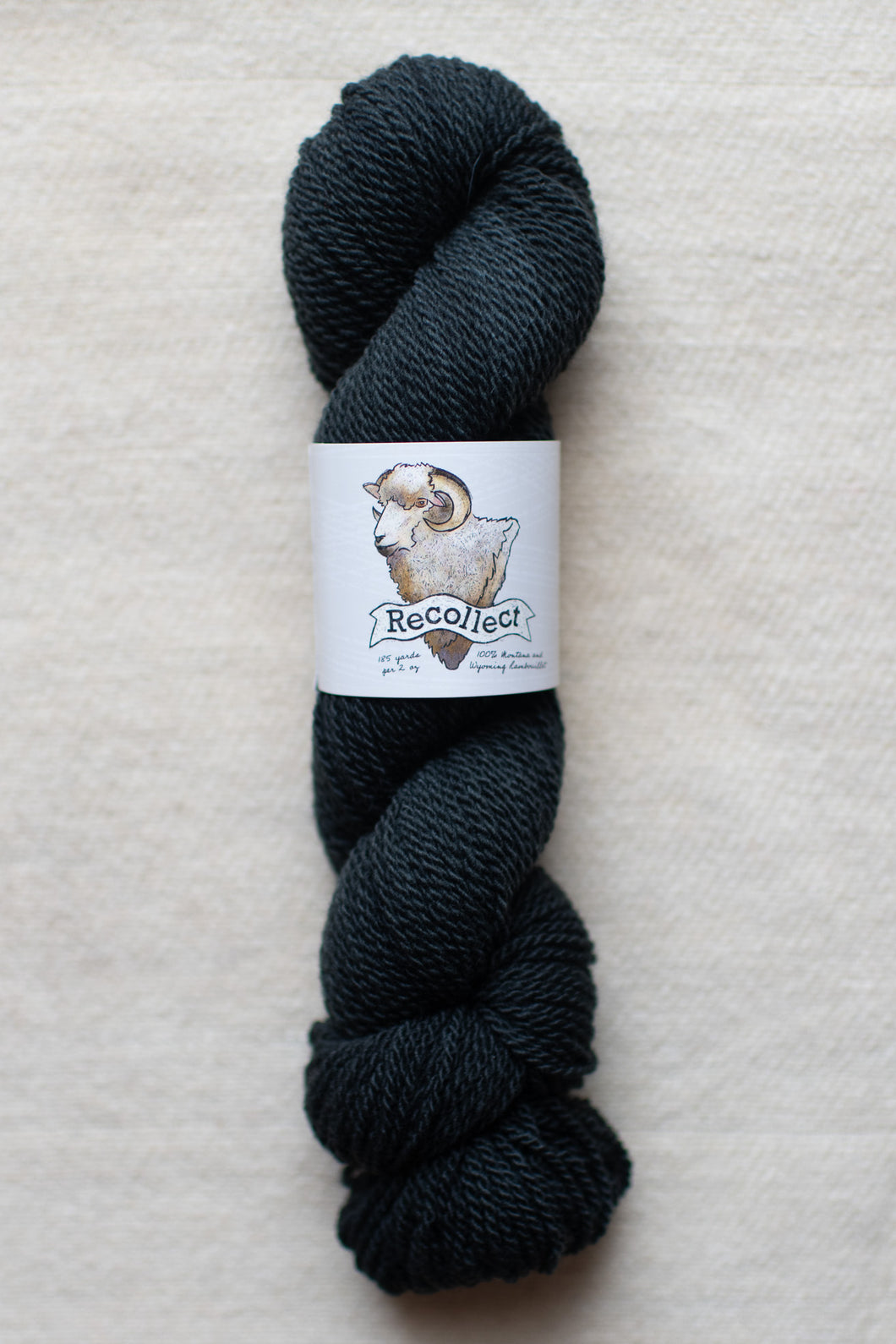 Dark blue skein of yarn with a label on a light gray background