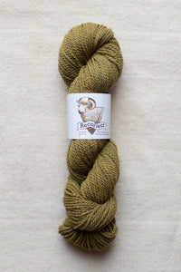 Ball of green yarn with a label on a beige background