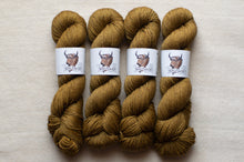 Load image into Gallery viewer, Four skeins of brown yarn with labels on a beige background