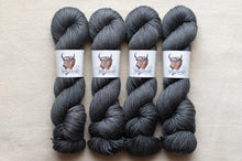 Load image into Gallery viewer, Four skeins of gray yarn with labels on a beige background