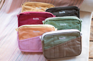 Set of colorful bags with 'Socila' branding on a wooden surface.