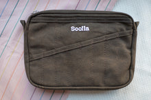 Load image into Gallery viewer, Brown pouch with 'Soolia' branding on a multicolored striped background