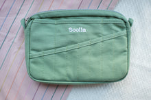 Load image into Gallery viewer, Green pouch with 'Soolia' branding on a pink background