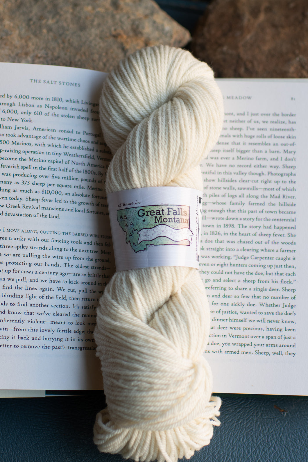 Skein of cream-colored yarn with a label on an open book