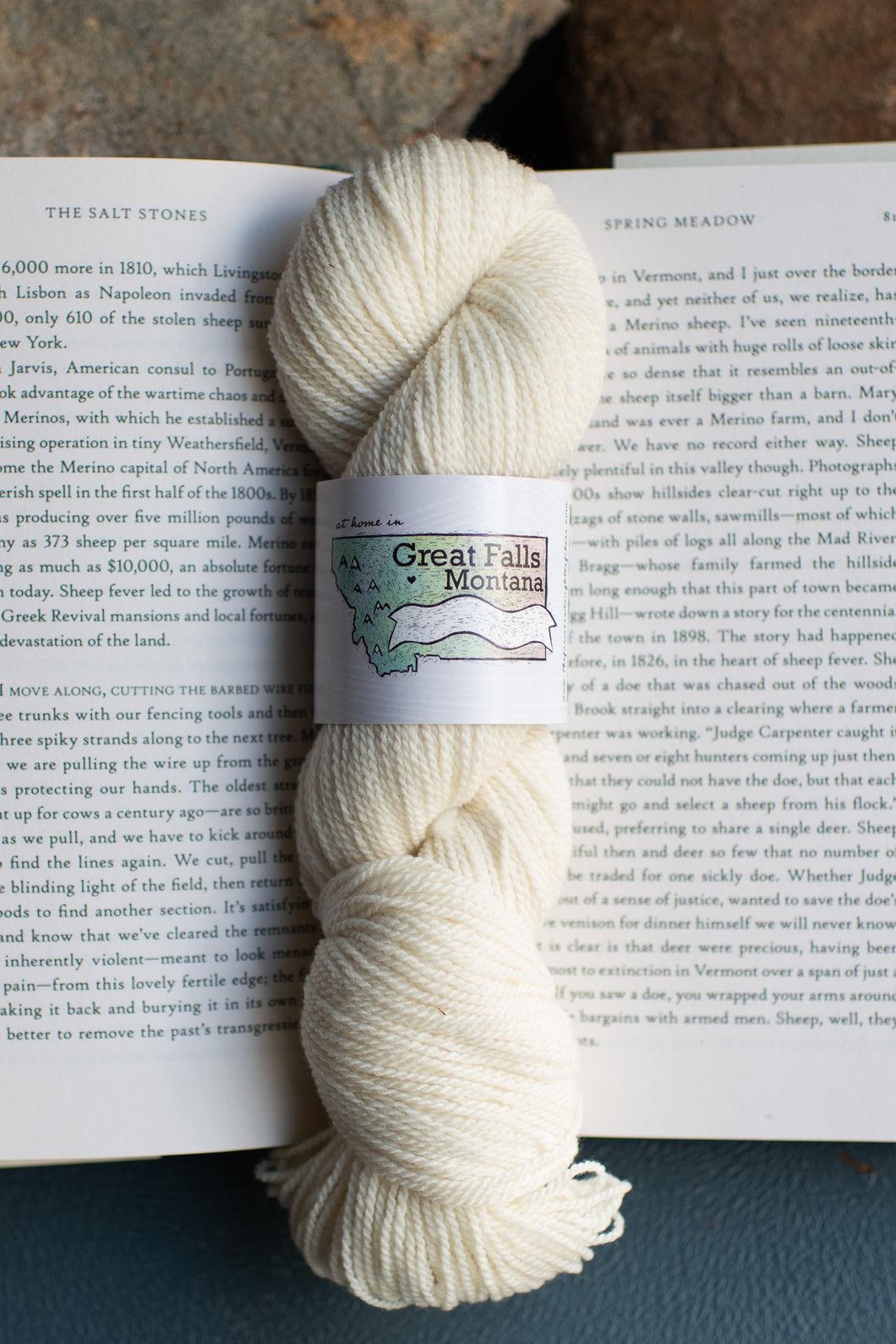 white skein of yard sitting on an open book