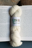 white skein of yard sitting on an open book