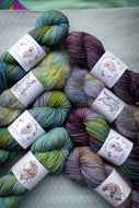 Assorted skeins of colorful yarn with labels on a textured surface