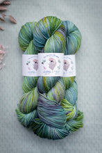 Load image into Gallery viewer, Multicolored skein of yarn with labels on a textured gray background