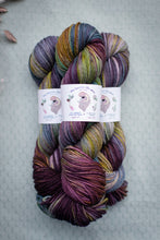 Load image into Gallery viewer, Multicolored skein of yarn with labels on a textured surface