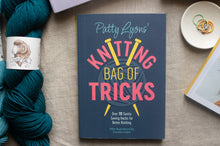 Load image into Gallery viewer, Book titled 'Knitting Bag of Tricks' by Patty Lyons with yarn and a bowl on a table.