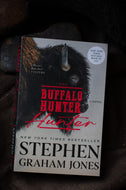 The Buffalo Hunter novel by Stephen Graham Jones, featuring a dark buffalo illustration on the front cover, photographed against a dark textured background.