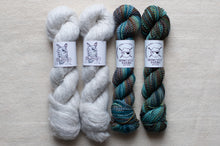 Load image into Gallery viewer, Two skeins of gray yarn and two skeins of multicolored yarn on a light gray background with &#39;Spincycle Yarns&#39; labels.
