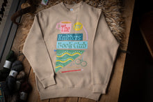 Load image into Gallery viewer, Beige sweatshirt with colorful graphic design on a wooden surface with yarn balls.