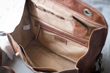 Load image into Gallery viewer, Open brown leather bag with visible stitching on a light background