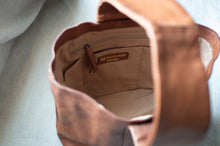 Load image into Gallery viewer, Brown leather bag with &#39;Redesigned&#39; label on a light gray background