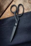Black scissors on a dark fabric background