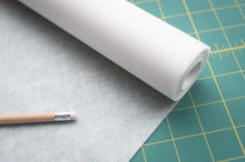 Load image into Gallery viewer, Roll of white paper on a cutting mat with a pencil next to it