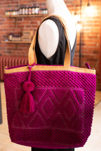 Load image into Gallery viewer, Mannequin wearing a pink textured handbag with a tassel in a store setting.