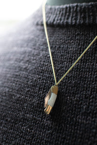 Necklace with a pendant on a dark textured fabric background