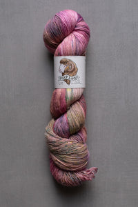 Multicolored skein of yarn with a label on a gray background