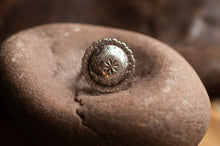 Load image into Gallery viewer, Silver ring with intricate design on a textured stone surface