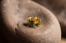 Load image into Gallery viewer, Gold ring with a horseshoe design on a stone surface